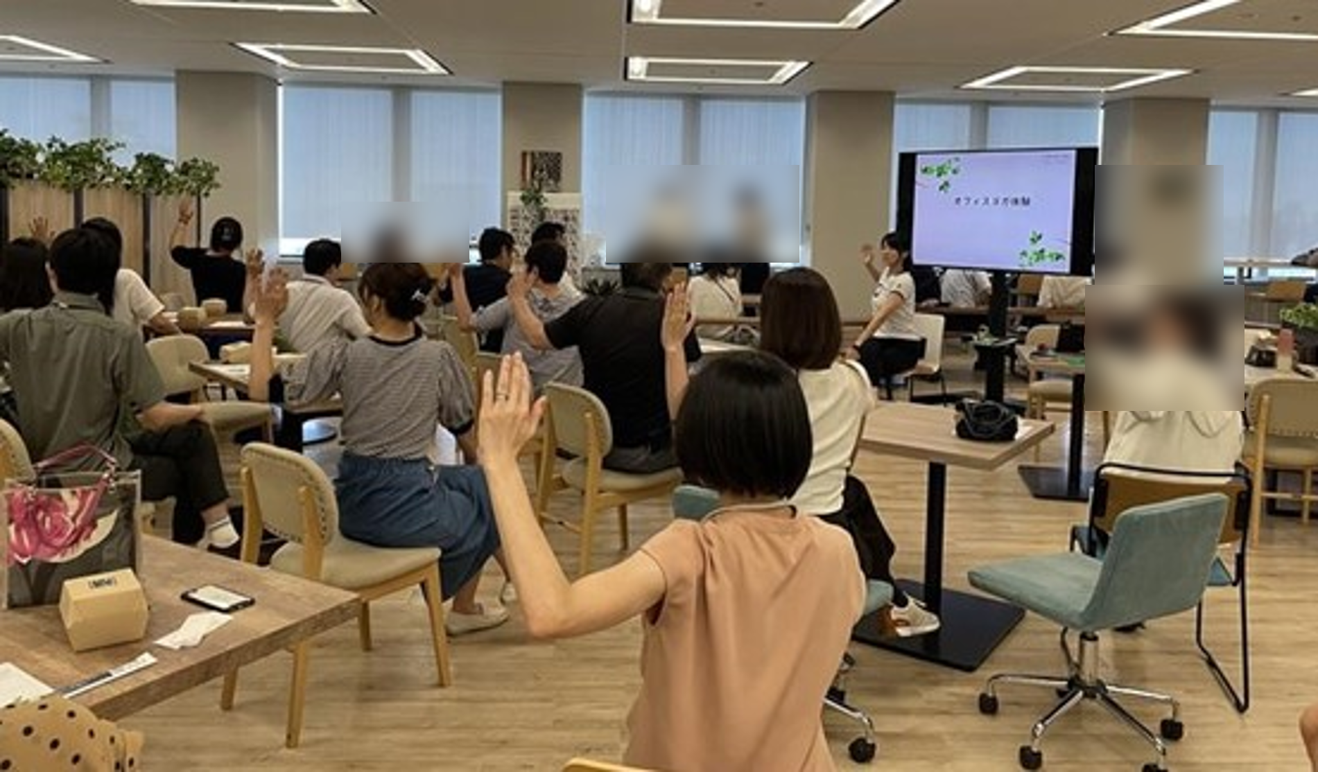 食堂で社員が椅子に座った状態で腰をひねってストレッチをしている画像