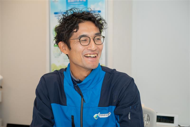 左を向いてインタビューに応える利根川さんの画像