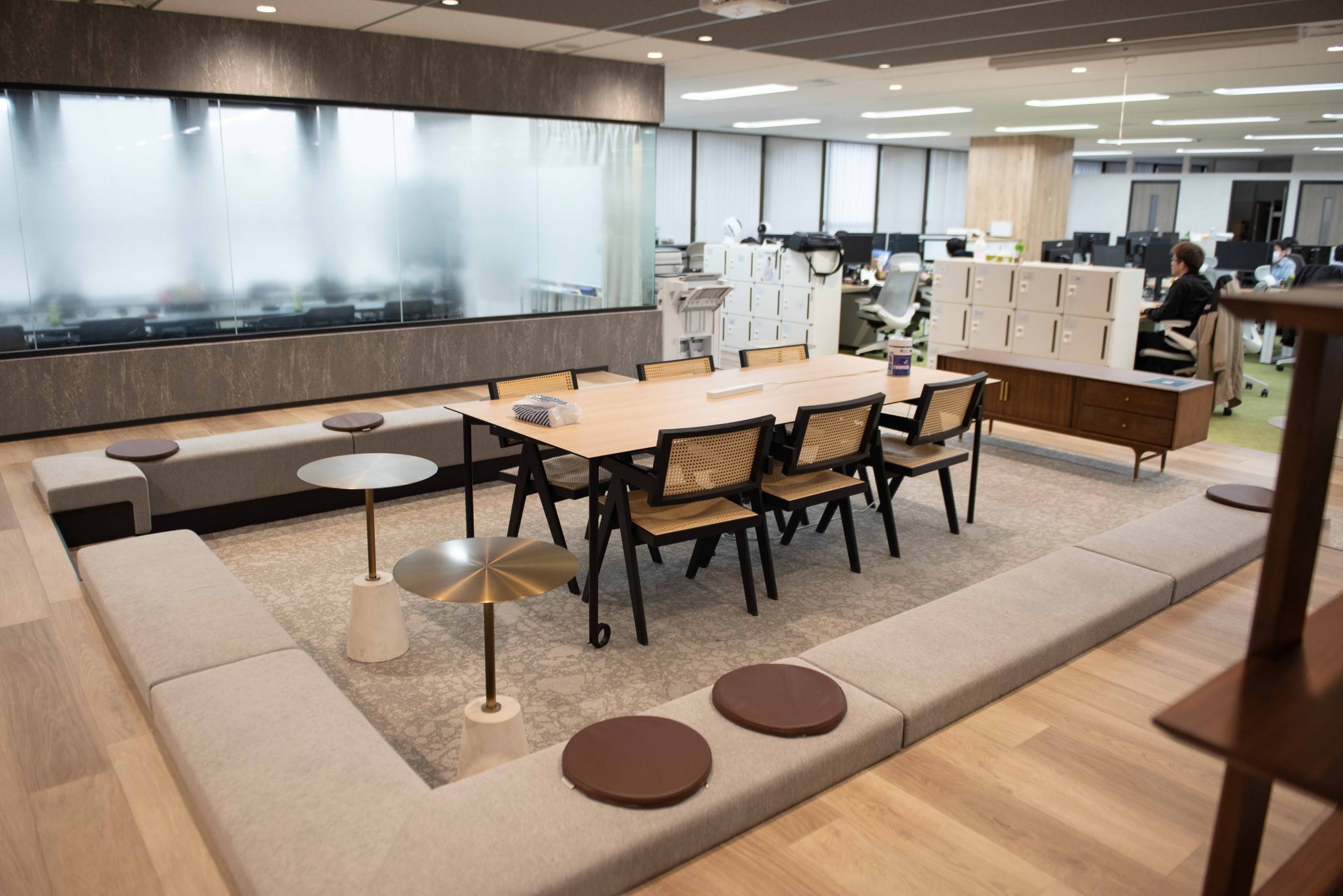 真ん中に6人がけのテーブルと椅子があり、再度テーブルやベンチが周りにある部屋の画像